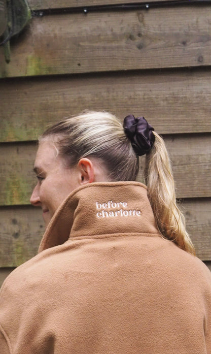 Maddi is wearing a the Jaipur camel 1/4 zip fleece here shown with our 'before charlotte' logo on the back of the collar.