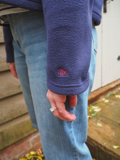 Close-up of Maddi wearing the Nantucket navy blue fleece with the BC logo on the cuff. 