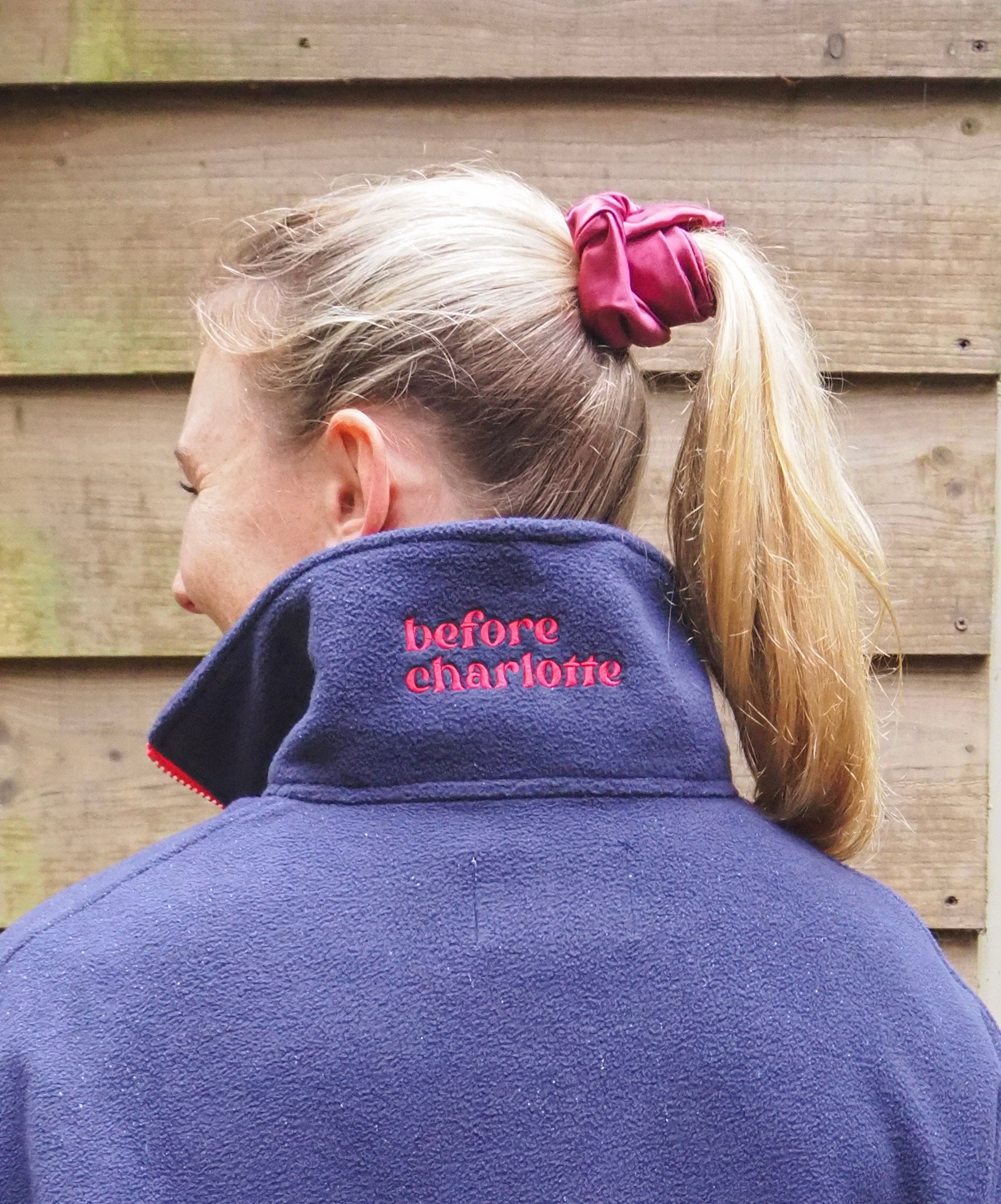 Maddi is wearing the Nantucket navy blue fleece 1/4 zip with 'before charlotte' embroidered on the back. 
